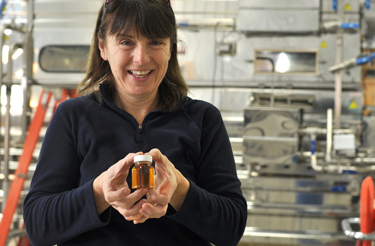 Photo of Cecile Branon holding a tiny jar of maple syrup
