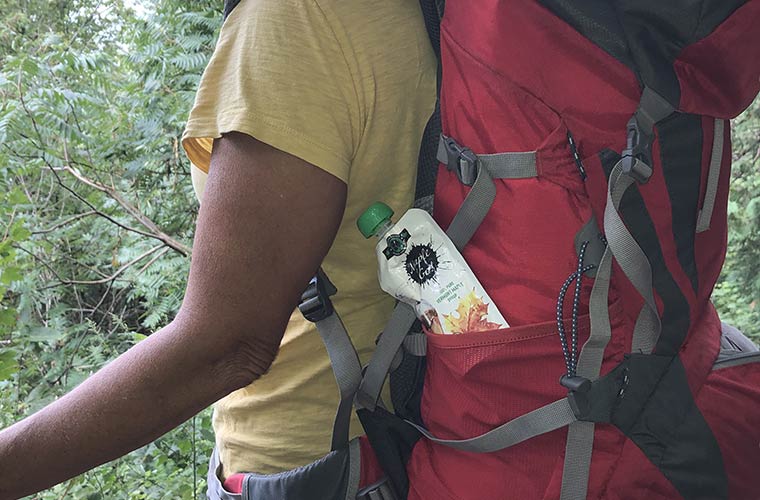 Photo of person hiking with a Maple To Go pouch in their backpack