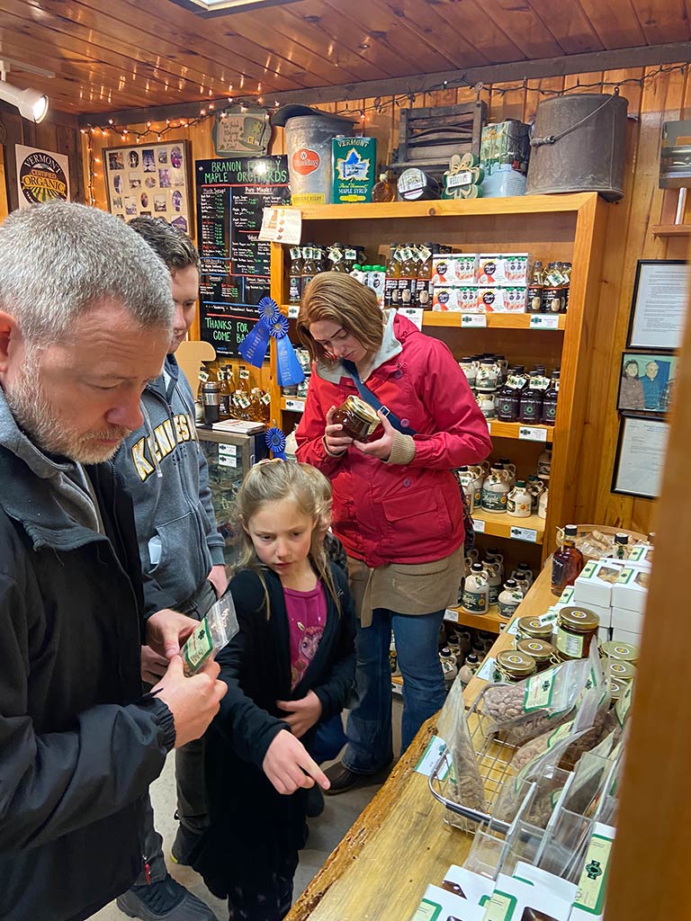 Photo of a family shopping, looking at maple products in a retail setting