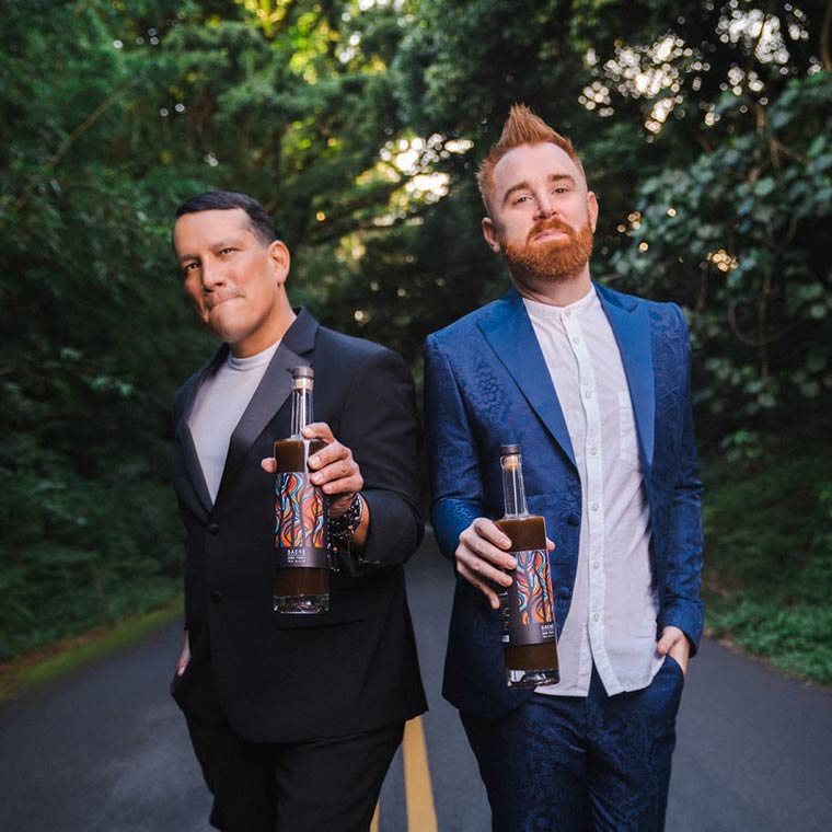Photo of Justin and husband Roger holding bottles of Woodnose Sacre