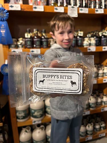 Photo of a little boy holding Buppy's Bites maple dog treats
